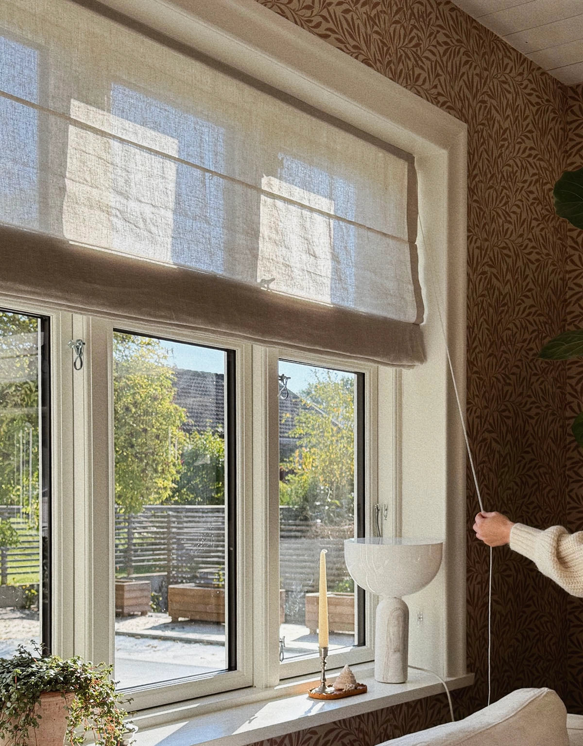 Beige hissgardin i lantligt fönster