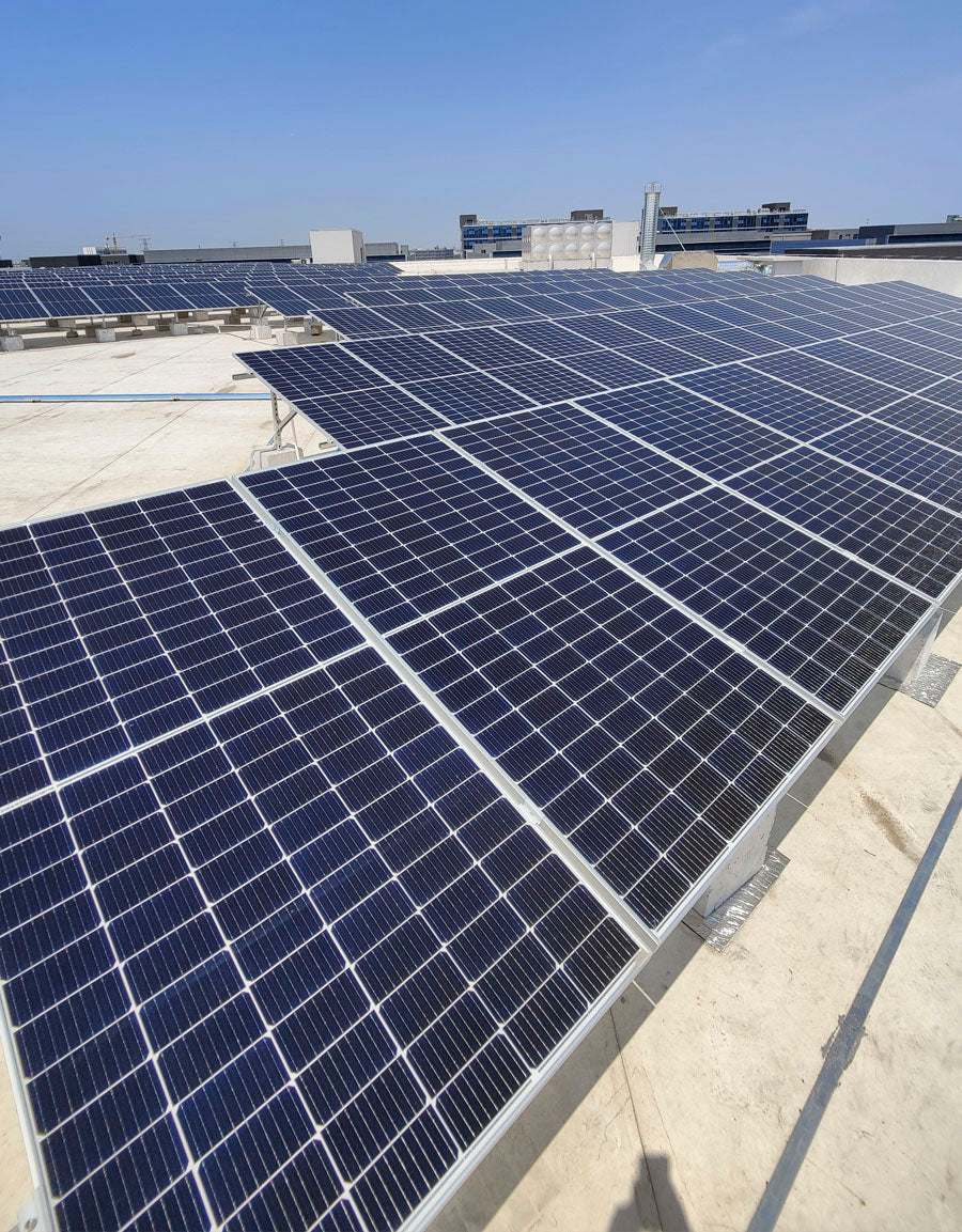 Solpaneler installerade på ett tak med klarblå himmel i bakgrunden