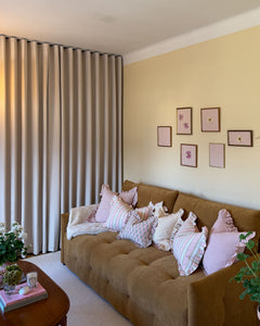 Mörkläggande beige gardin som rumsavdelare i ett vardagsrum