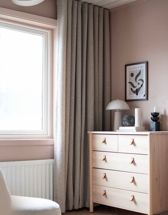 Gardin Hilma i taupe, veckad framför ett fönster