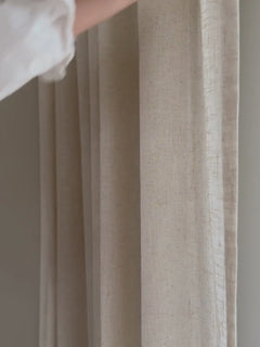 Hand som stryker över beige gardin