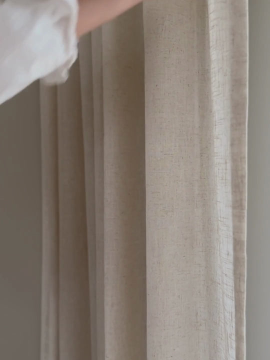 Hand som stryker över beige gardin